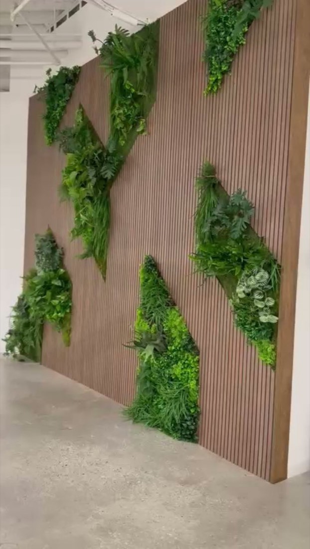 Geometric green-wall insets set diagonally into a wood-slat feature wall